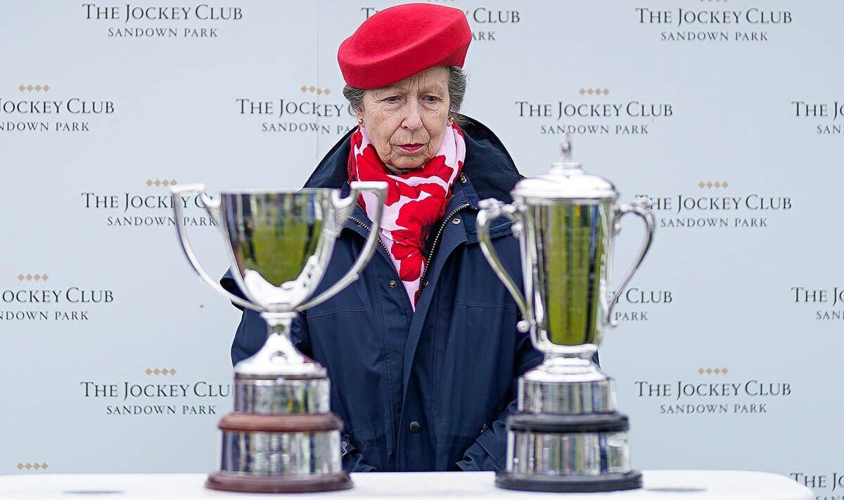 Princess Anne braves the rain in chic navy raincoat and red beret