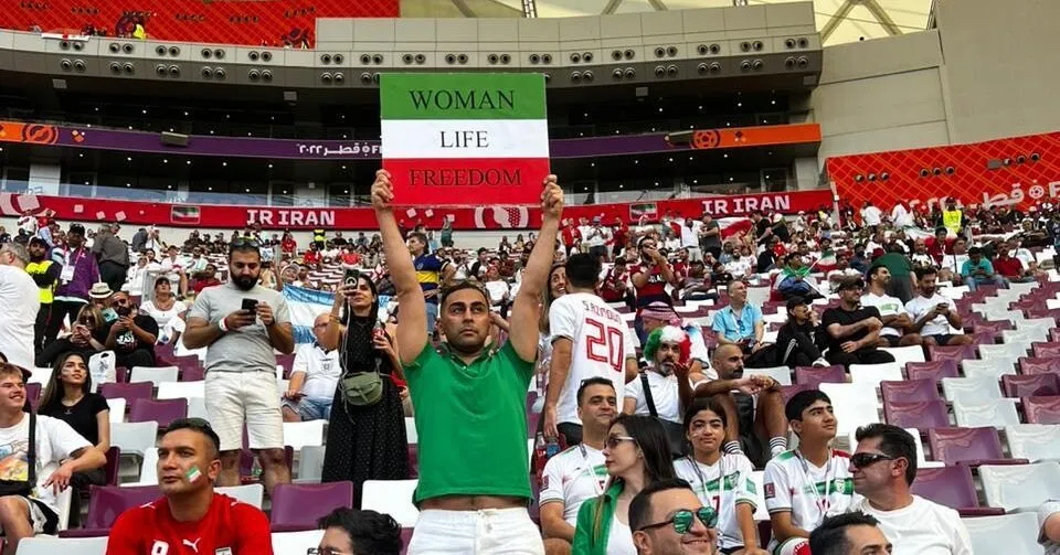 Iranian fans with pre-revolutionary flags are denied entry to the England game.